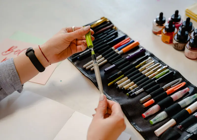 Hands preparing to use colorful brush pens for a craft project
