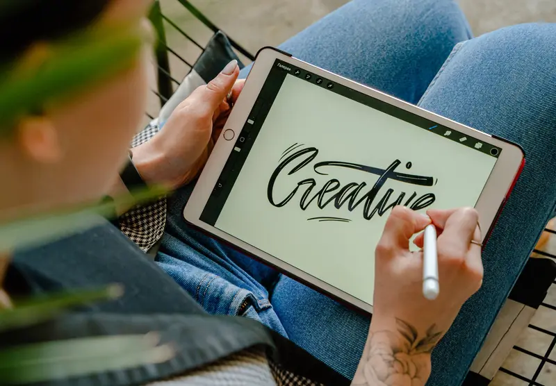 Person using stylus pen on tablet for digital lettering showing creativity in design