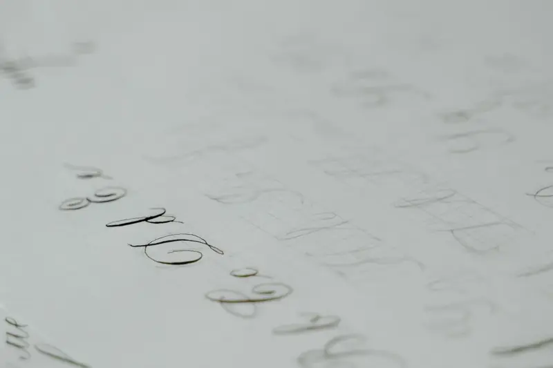 Close-up of a calligraphy practice sheet with elegant cursive lettering on white paper