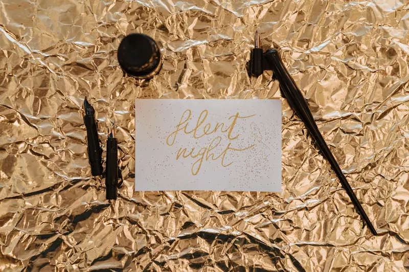 A sophisticated 'Silent Night' card featuring gold calligraphy on a crumpled foil background