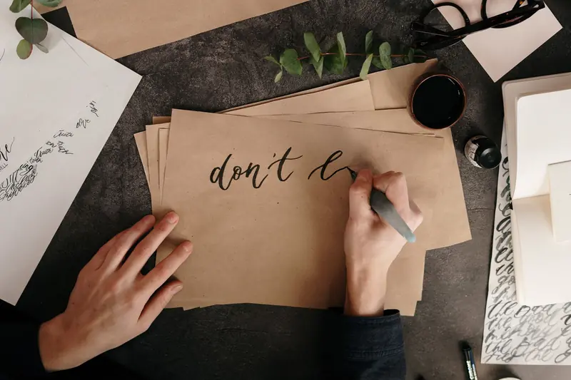 Top view of hand lettering with ink on craft paper for a creative project