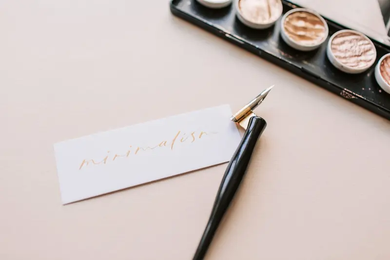 Beautiful minimalist calligraphy spelling 'minimalism' with a stylish pen on neutral paper
