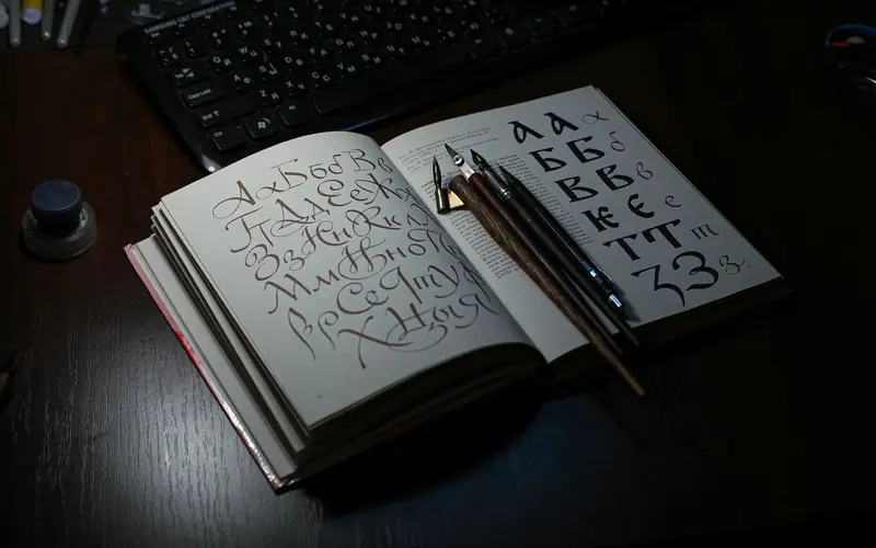 Open book showing Cyrillic calligraphy with quill pens on a desk, ideal for art and language themes